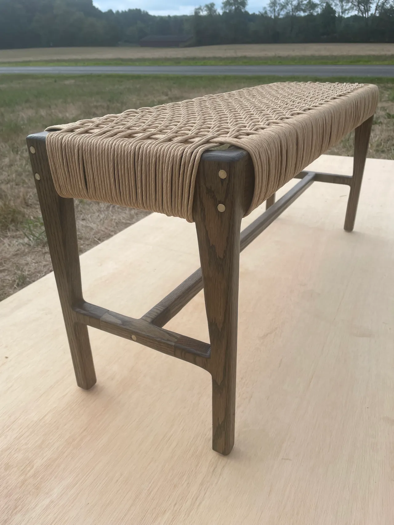 Side view of the dark bench showing the cord weave