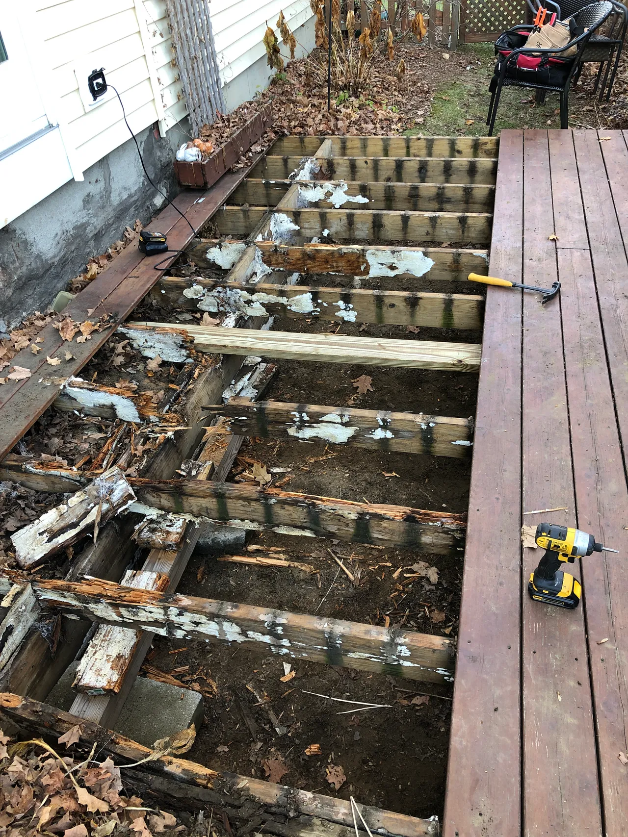 Deck with boards removed showing rotted joists being replaced