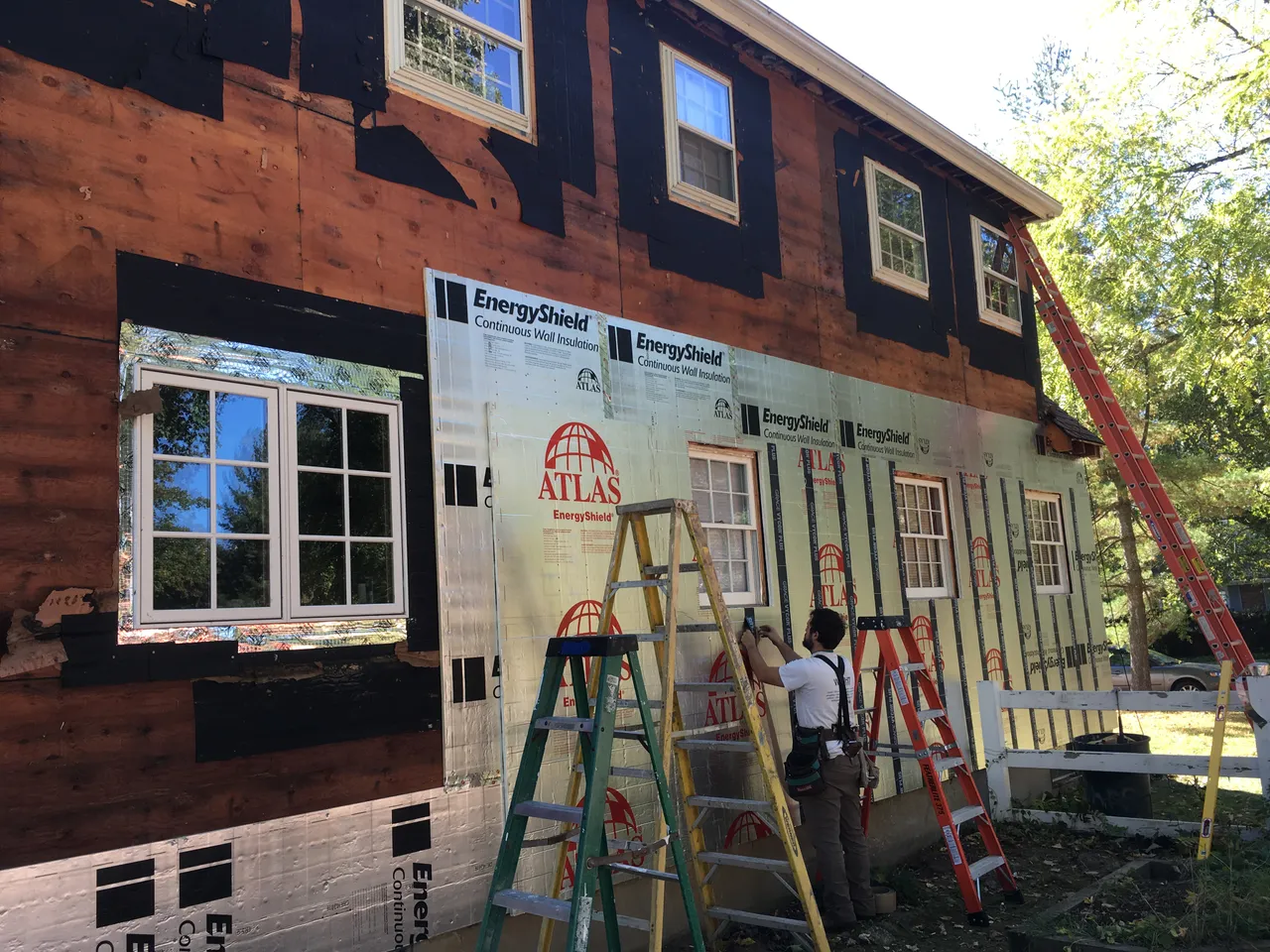 House wall with old siding removed and rigid foam going on