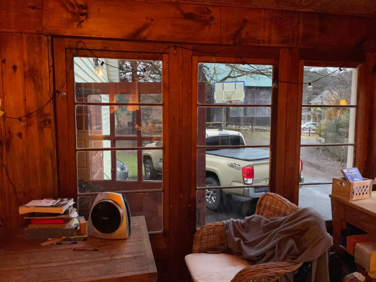 Porch before renovation with dark wood walls and old windows