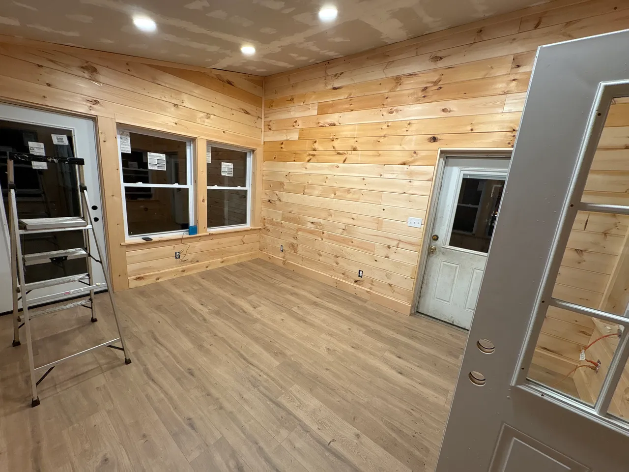 Sunroom interior with pine walls, recessed lights and new flooring